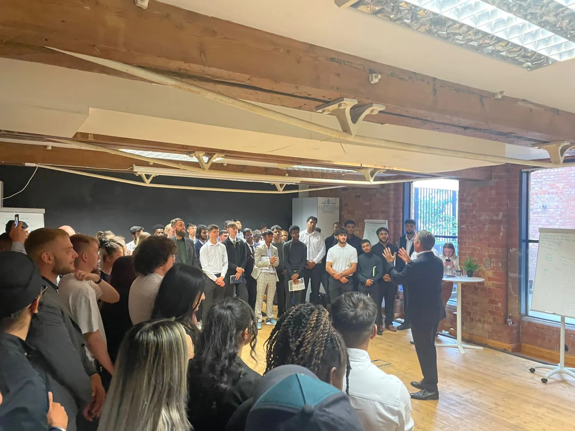 Speaker addressing a crowd at an Xelence networking event